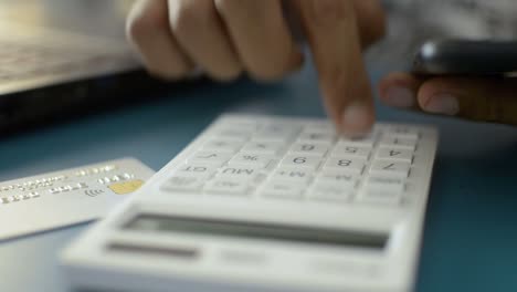 Hands-of-a-man-calculating-expenses-from-credit-card.