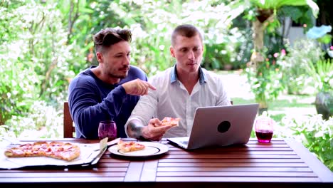 Gay-couple-having-pizza-for-lunch.-Disagree-on-something.