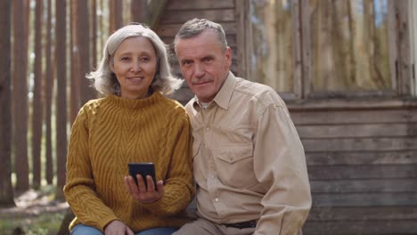 Portrait-of-Aged-Couple-near-Wooden-Country-House