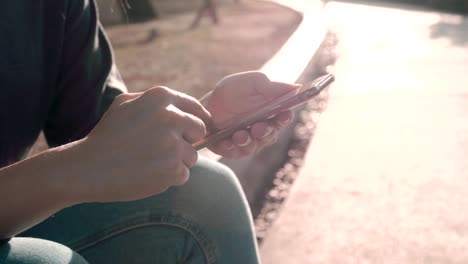 Frau-benutzen-Handy-und-sitzen-auf-dem-Park-mit-Sonnenlicht-Effekt