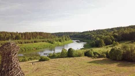 Aerial-view-of-the-Russian-forest,-river-and-steppe-overlooking-an-abandoned-Church-and-architectural-objects