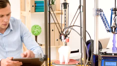 Concentrated-man-working-with-3d-printer