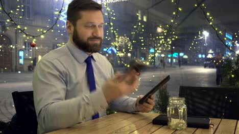 Geschäftsmann-Surfen-Tablet-Antworten-Telefon,-Café,-Abend,-Weihnachten