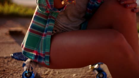 Beautiful-young-girl-sitting-on-skateboard-and-texting