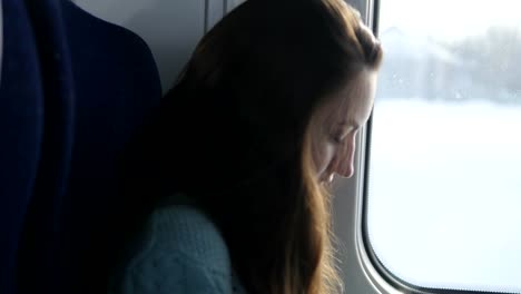 Young-girl-traveling-in-a-train-and-using-mobile-phone.-Beautiful-woman-sends-a-message-from-the-smartphone.-Attractive-girl-chatting-with-friends.