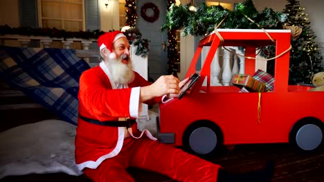 Joyous-Santa-Claus-enjoying-with-modern-gadget