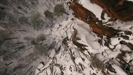 Aerial-view-of-a-rock-climber-climbing-a-steep-cliffs-during-a-sunny-winter-day.