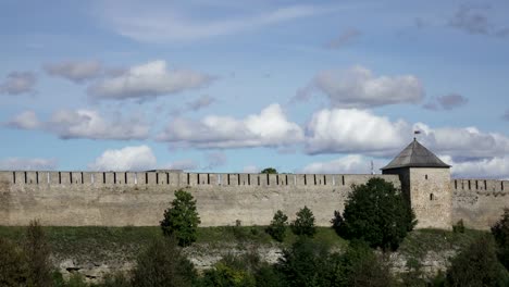 Beautiful-cityscape,-medieval-touristic-attraction-on-Russian-Estonian-border,-Ivangorod-fortress-on-banks-of-Narva-river,-cloudy-sky-horizon