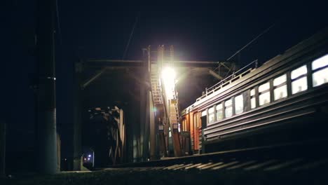 Passenger-train-crosses-bridge-at-night