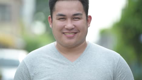 Young-handsome-overweight-Asian-man-in-the-streets-outdoors