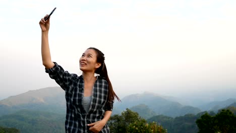 4K-footage.-beautiful-Asian-woman-having-video-chat-by-using-smartphone-outdoors-sharing-travel-nature-view-with-friends-or-live-stream-via-social-media.