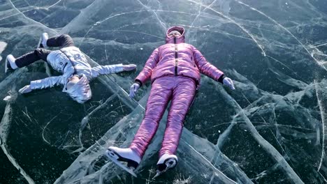 Family-is-ice-skating-at-day.-Girls-to-ride-figure-ice-skates-in-nature.-Mother-and-daughter-riding-together-on-ice-in-cracks.-Outdoor-winter-fun-for-athlete-nice-winter-weather.