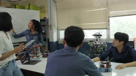 Electronics-engineer-team-meeting,-collaborating-on-construction-of-robot-in-the-workshop.-People-with-technology-or-innovation-concept.