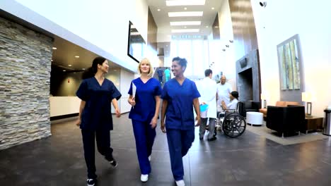 Multi-ethnic-nurses-wearing-scrubs-in-hospital-entrance