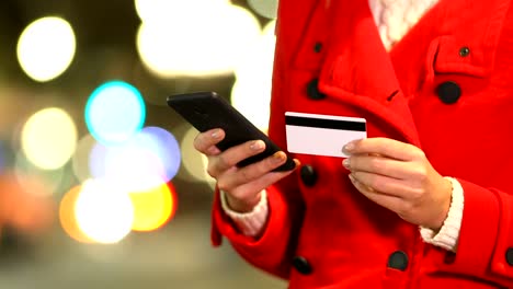 Frau-Hand-in-einer-Winternacht-im-Internet-bezahlen