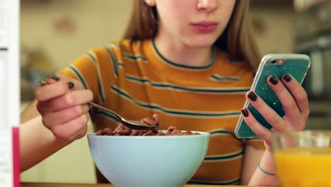 Teenager-Mädchen-essen-ungesund-Schale-mit-zuckerhaltigen-Frühstück-Getreide-SMS-auf-Handy