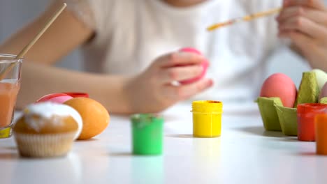 Girl-painting-Easter-egg-with-yellow-color,-family-traditions,-art-school-lesson