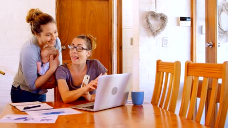 Lesbian-couple-working-on-laptop-in-living-room-4k