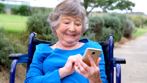 Senior-woman-using-mobile-phone-on-wheelchair-4k