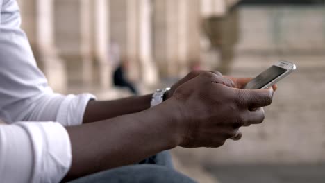 Technology,devices,communication.-Black-man's-hands-typing-on-smartphone-outdoor