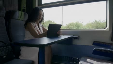 Businesswoman-conmutando-a-la-oficina-en-el-tren-de-trabajo-en-Tablet-PC