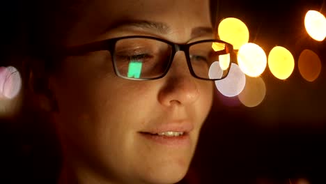 Portrait-of-young-beautiful-caucasian-woman-using-smart-phone-hand-hold-outdoor-in-the-city-night,-smiling,-face-illuminated-screenlight---social-network,-technology,-comunication-concept