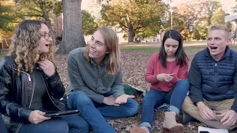 Estudiante-de-la-Universidad-femenina-mirando-su-teléfono-móvil-en-un-grupo-de-ajuste-fuera