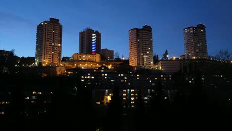 Timelapse-movement-of-clouds-over-the-houses-in-the-city.-Sunset-over-the-city.-In-the-Windows-of-houses-lights-up