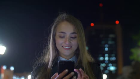 Caucasian-businesswoman-using-mobile-phone-to-type-email-outside