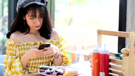 Asiatische-junge-Frau-fotografiert-Frühstück-mit-Smartphone-Social-Media