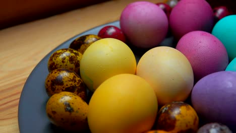 Woman's-hand-puts-red-and-green-colored-quail-egg