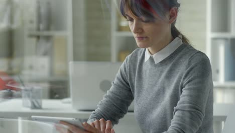 Businesswoman-Working-on-Digital-Tablet-at-Office-Desk