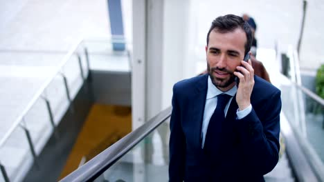 A-businessman-answering-the-phone,-send-messages-and-smiles-for-the-beautiful-job-news-and-in-the-background-you-see-a-people.