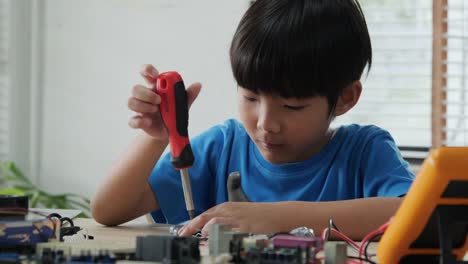 Boy-try-to-fixing-computer-board-in-school-science-club.-Project-for-engineering-club-in-school.-People-with-technology-concept.