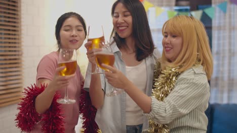 Group-of-Asian-women-party-at-home,-female-drinking-cocktail-dancing-and-singing-having-funny-moment-in-living-room-in-night.-Teenager-young-friend-play-game,-celebrate-holiday-concept.-Slow-motion.