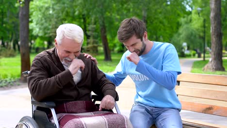 Aged-male-in-wheelchair-and-volunteer-laughing-and-joking,-having-fun-together