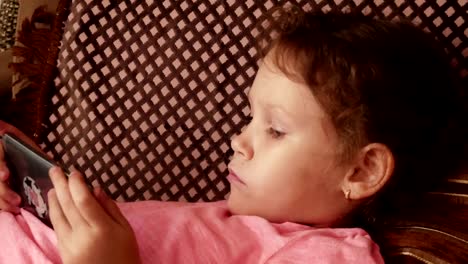 Little-girl-playing-in-game-on-smartphone