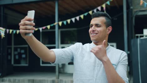 Porträt-von-freudigen-gemischten-Rennen-Mann-macht-Selfie-im-Freien-mit-Smartphone-Kamera