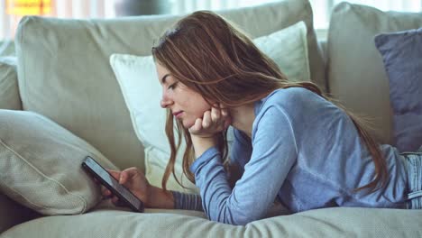 Young-woman-using-mobile-phone-at-home