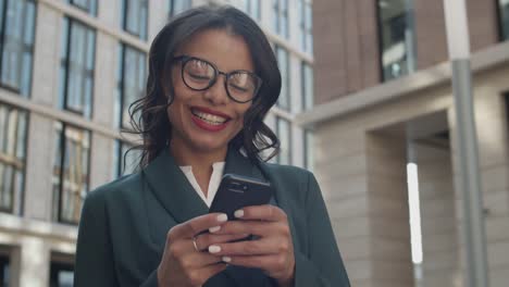 Happy-Businesswoman-Using-Smartphone-Outdoors