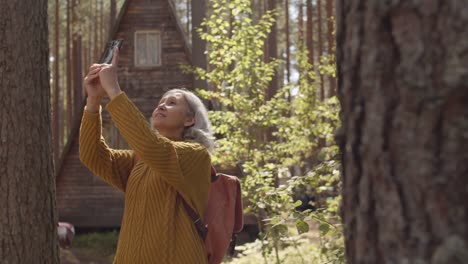 Turista-Haciendo-Fotos-cerca-de-Wooden-Cabin-in-Woods