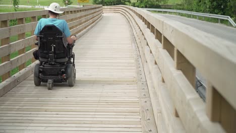 4k-resolution-video-of-a-man-on-electrical-wheelchair-driving-on-foot-path