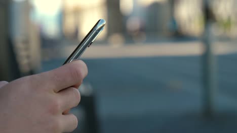 Hipster-Mann-Hände-mit-seinem-Smartphone-im-Freien-im-Park