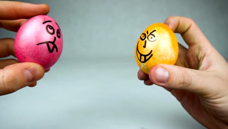 Hands-hold-Easter-dyed-and-painted-colored-eggs-with-drawn-smilies-or-faces,-concept-of-Christian-feast-Pascha-or-Resurrection-Sunday