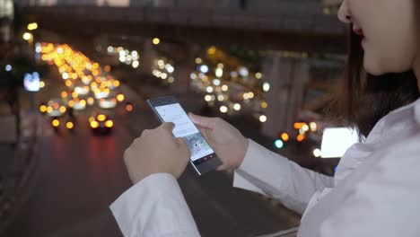 Close-up-Hand-of-business-woman-using-smart-phone-in-the-modern-city-center-in-the-twilight-of-Bangkok-Thailand.-Concept-Technology-communication-by-mobile-phone