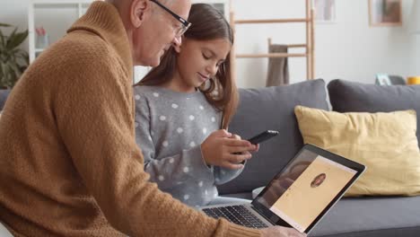 Elderly-Man-Mastering-Messenger-with-Help-of-Granddaughter