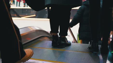 Legs-of-People-Moving-on-an-Escalator-Lift-in-the-Mall.-Shopper's-Feet-on-Escalator-in-Shopping-Center