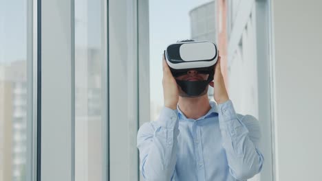 Close-up-Young-man-sitting-at-a-desk-in-the-office-uses-augmented-reality-glasses-to-work-on-business-projects-in-various-fields.-Work-in-Virtual-Reality