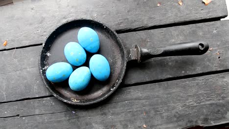 Easter-eggs-in-a-frying-pan-on-rustic-wooden-background