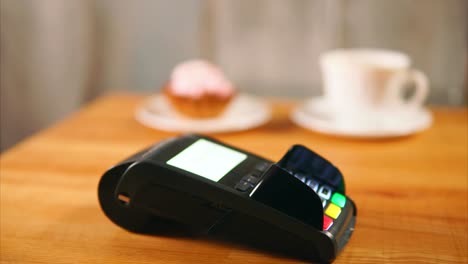 Close-up-view-of-contactless-payment-in-store.-Vendor-put-the-payment-terminal